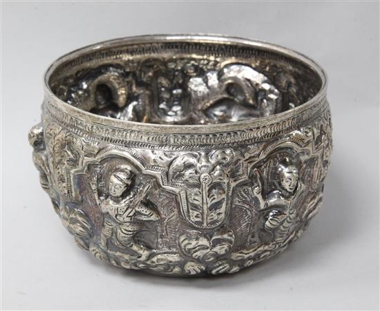 A Burmese repousse white metal bowl, decorated with deities, height 9cm.